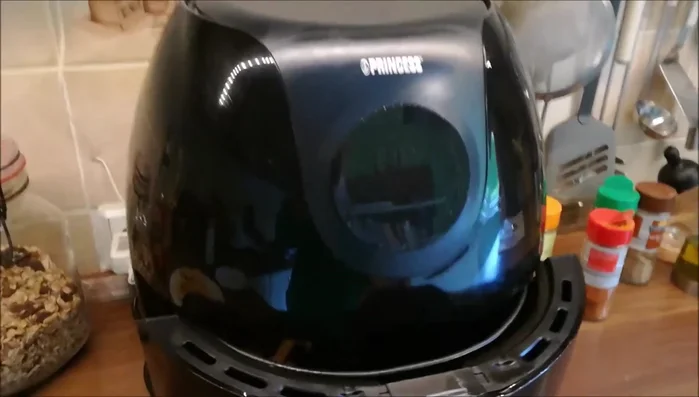 Fertige Kohlrabi-Pommes aus der Heißluftfriteuse nehmen.