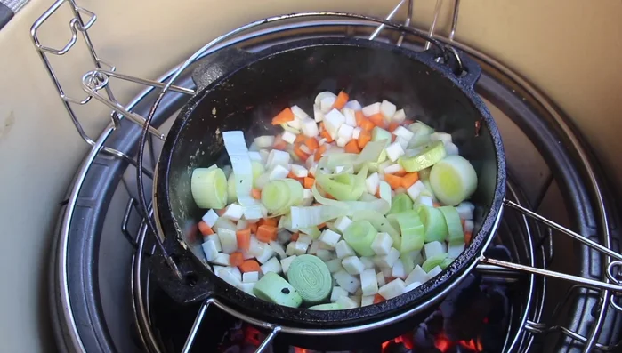 Zwiebeln und Knoblauch, dann das vorbereitete Gemüse im Dutch Oven anrösten. Tomatenmark hinzufügen und ebenfalls anrösten.