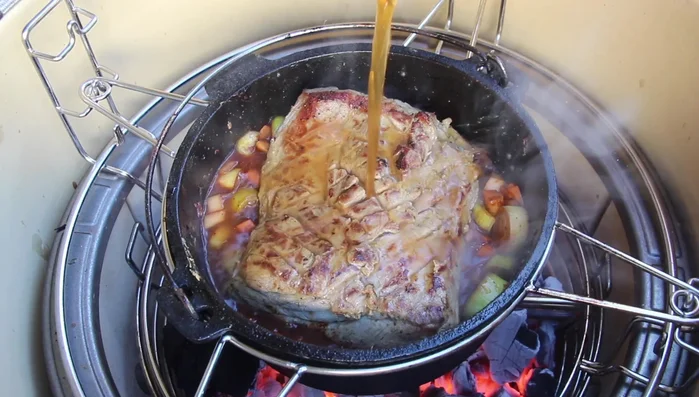 Schweinenacken in den Dutch Oven geben, Deckel schließen und bei 160 Grad 2,5 Stunden schmoren.