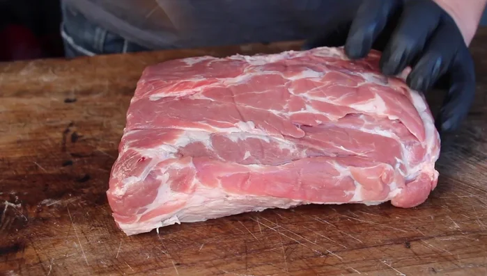 Schweinenacken kreuzweise einschneiden und mit Salz, Pfeffer und mittelscharfem Senf einreiben.