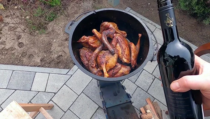 Eine Flasche Rotwein in den Dutch Oven geben.