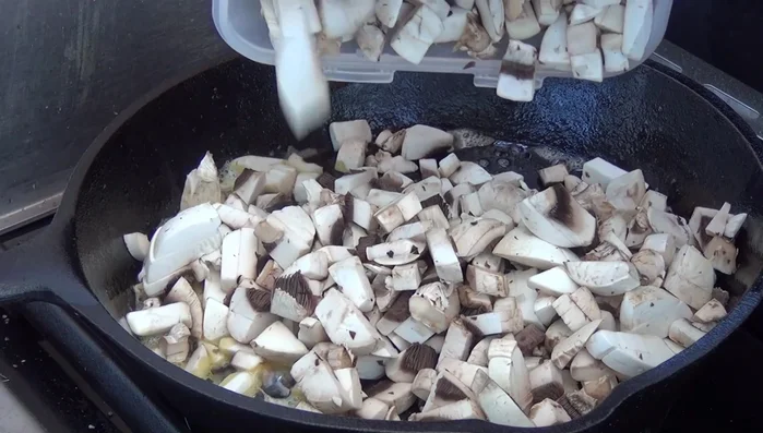 Champignons auf dem Seitenbrenner andünsten. Ein bisschen Butter in die Pfanne geben.
