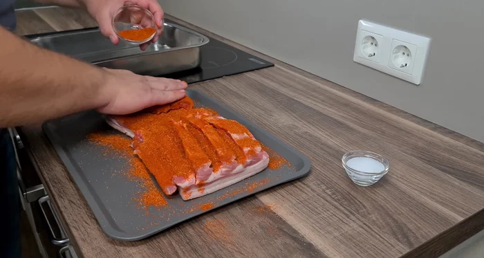 Untere Seite des Bauches mit Salz, Pfeffer und Paprikapulver bestreuen. Seiten nur mit Salz.
