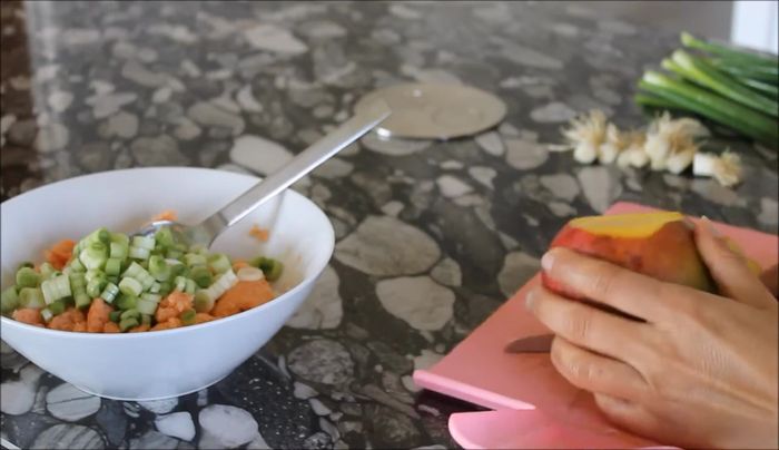 Mango in kleine Stücke schneiden und ebenfalls hinzufügen.