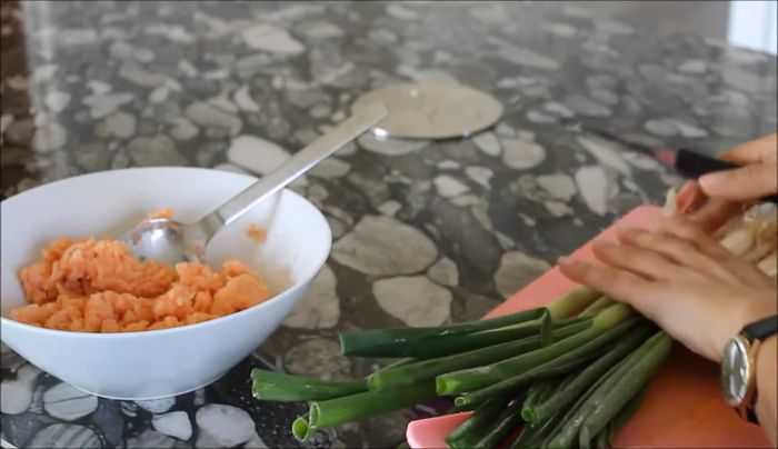 Lauchzwiebeln in feine Ringe schneiden und zum Räucherlachs geben.