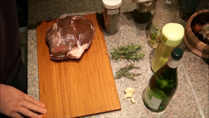 Marinade zubereiten: Majoran, geschroteten Pfeffer, Pflanzenöl, grobes Meersalz, trockenen Weißwein, Rosmarin, Thymian und zerdrückten Knoblauch vermischen.