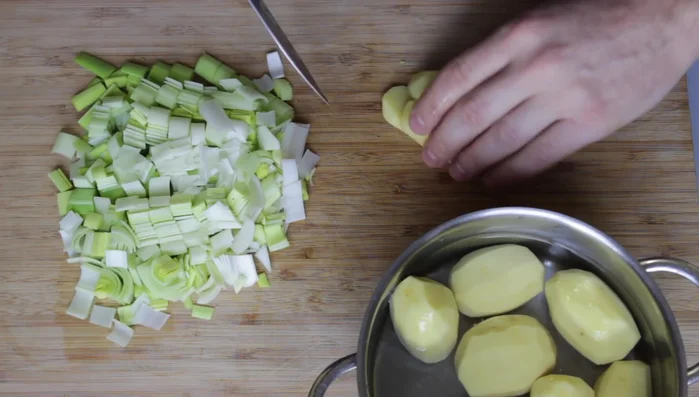 Kartoffeln in Würfel schneiden und zum Gemüse geben.