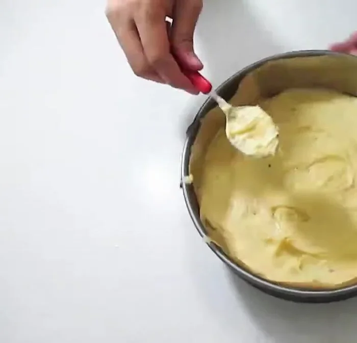 Hälfte des Teiges in vorbereitete Tortenform geben (214.15). Mit Baiser bedecken (223.9).