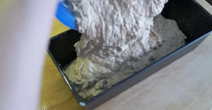 Teig in die Form geben und mit Sonnenblumenkernen bestreuen.