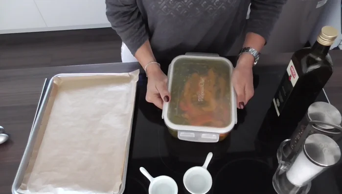 Gewürzte Kürbisspalten auf ein Backblech legen.