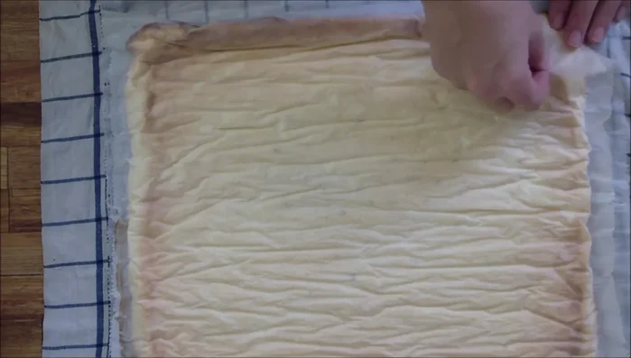 Backpapier von der Biskuitrolle entfernen und mit der Frischkäse-Creme bestreichen. (2:254.3)