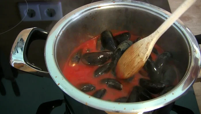 Miesmuscheln in die Soße geben, umrühren und bei niedriger Hitze (Stufe 2 von 9) ca. 10 Minuten köcheln lassen, dabei gelegentlich umrühren.