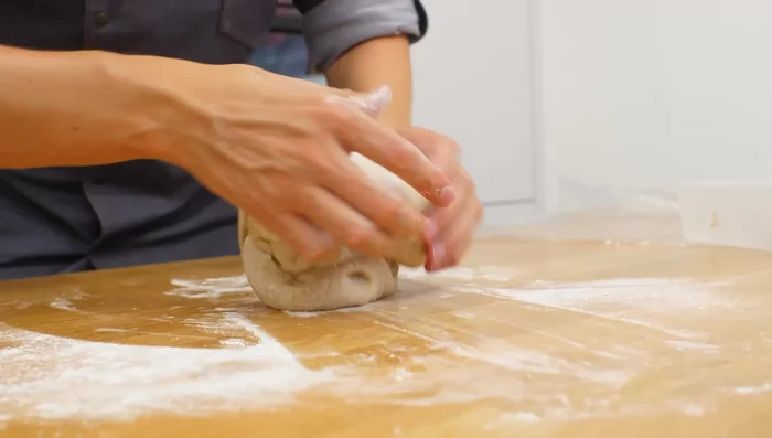 Teig zu einem Laib formen, mit der Naht nach unten in eine gefettete Gärform legen und im Kühlschrank 12-16 Stunden gehen lassen.