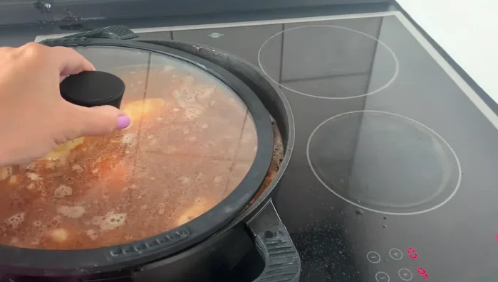 Topf abdecken und köcheln lassen (mittlere Stufe), bis das Wasser verdampft ist und der Reis gar ist.