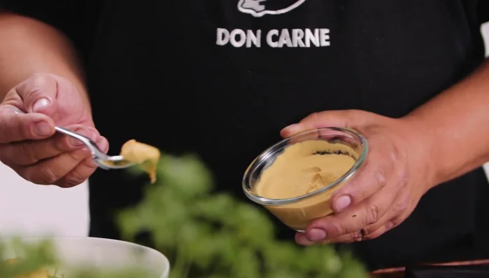 Kartoffelsalat mischen: Kartoffeln und Gemüse mit dem Dressing vermengen.