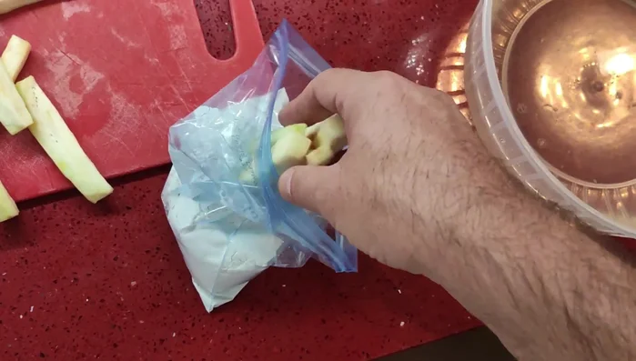 Die abgetrockneten Auberginenstreifen im Mehl wenden (am besten in einem Gefrierbeutel).