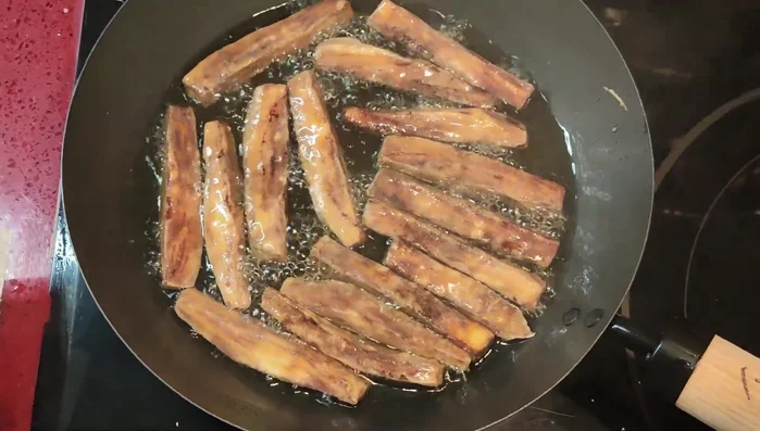 Die frittierten Auberginen auf Küchenpapier legen, um überschüssiges Öl zu entfernen.