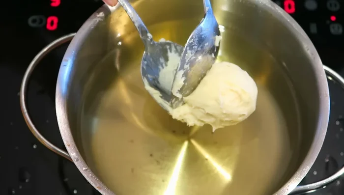 Quarkbällchen von jeder Seite 2-3 Minuten goldbraun frittieren.