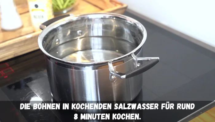 Bohnen in Salzwasser mit 1 TL Backpulver/Natron ca. 8 Minuten kochen.