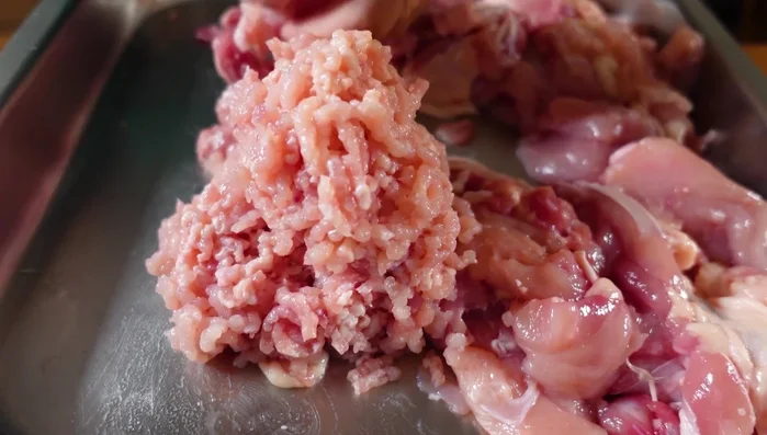 Hähnchenfleisch (mit Haut) durch den Fleischwolf geben (ggf. zweimal).