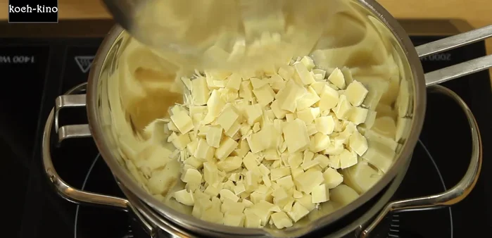 Weiße Schokolade und Butter mit einem Teil Wasser über einem heißen Wasserbad schmelzen. Achten Sie darauf, dass die Schüssel nur mit dem Wasserdampf und nicht direkt mit dem Wasser in Berührung kommt.