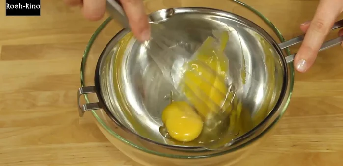 Eigelb, Vanillepaste, Zucker und restliches Wasser verrühren und über einem heißen Wasserbad aufschlagen, bis die Masse dickflüssig wird (ca. 5-8 Minuten).