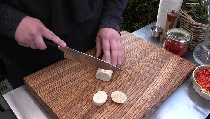 Baguette in Scheiben schneiden und halbieren, Mozzarella in kleine Würfel schneiden.