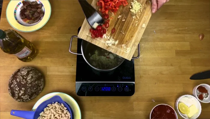 Zwiebeln, Chili Tomaten, Paprika und Knoblauch zum Rindfleisch geben und ca. 4-5 Minuten anbraten.