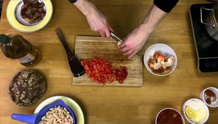 Zwiebeln halbieren und in Streifen schneiden.