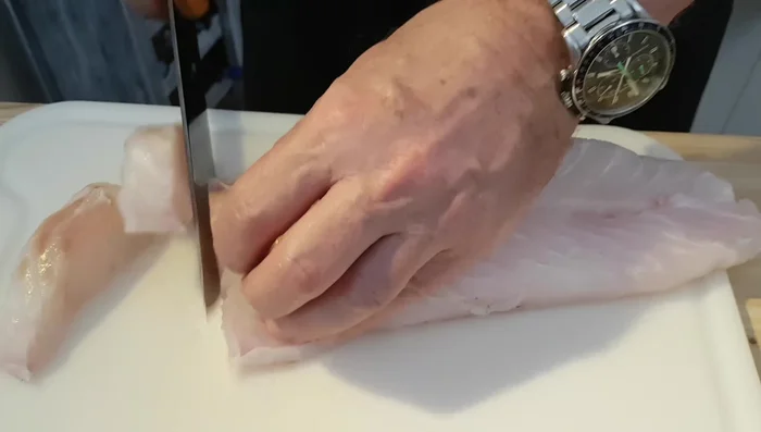 Kabeljaufilet in kleine Stücke schneiden (für einfacheres Wolfen).