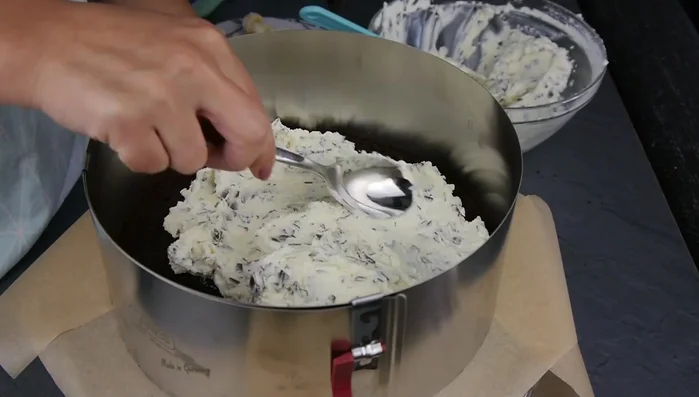 Hälfte der Creme auf den Boden streichen, Bananenscheiben darauf verteilen, restliche Creme daraufgeben und glatt streichen.