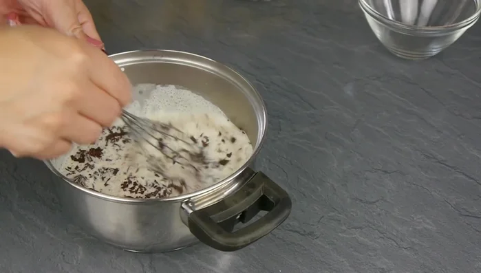 Zartbitter Schokolade mit Sahne schmelzen, über die Torte geben.