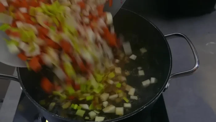 Passierte Brühe wieder zum Kochen bringen. Das vorbereitete Gemüse hinzufügen.