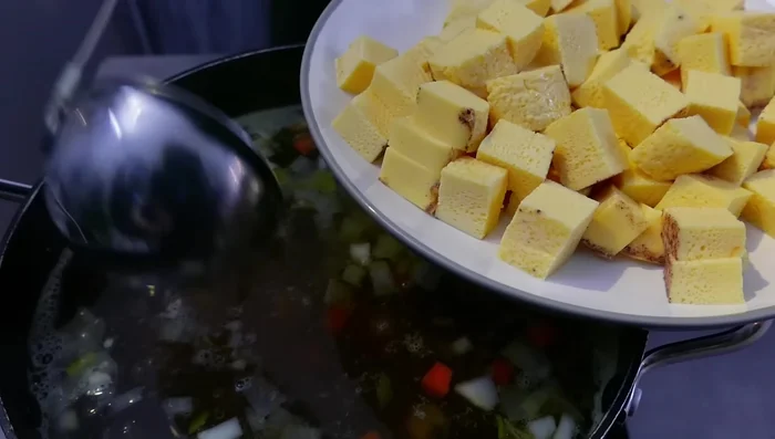 Eierstich, Klößchen und Fleisch in die Suppentassen geben.