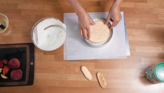 Den zweiten Löffelbiskuitboden auflegen und andrücken.