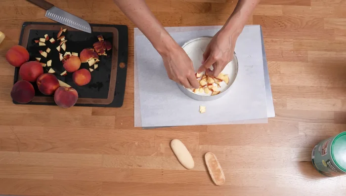Pfirsichwürfel auf der Torte verteilen.