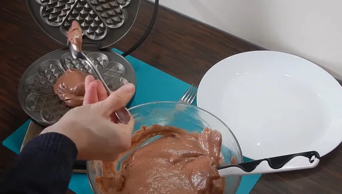 2 gut gehäufte Esslöffel Teig pro Waffel ins heiße Waffeleisen geben.