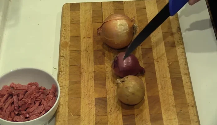 Zwiebeln in feine Streifen oder Ringe schneiden (rote Zwiebeln empfohlen).