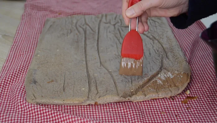 Biskuitrolle vorsichtig ausrollen und mit der Schokolade bestreichen. Quarkmasse darauf verteilen.