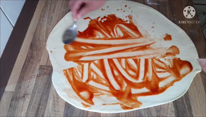 Für den zweiten Hefezopf: Teig ausrollen, passierte Tomaten mit Salz und Oregano, Mozzarella darauf verteilen und einrollen (399.73).