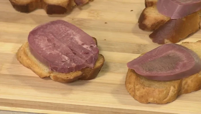 Die Ochsenzunge in Scheiben schneiden und auf dem gerösteten Brot anrichten.