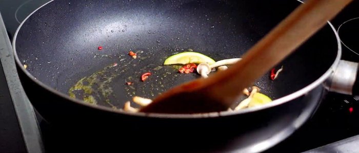 Buchenpilze, Chilischote und Zucchini hinzufügen und kurz anbraten, mit Salz und Pfeffer würzen.