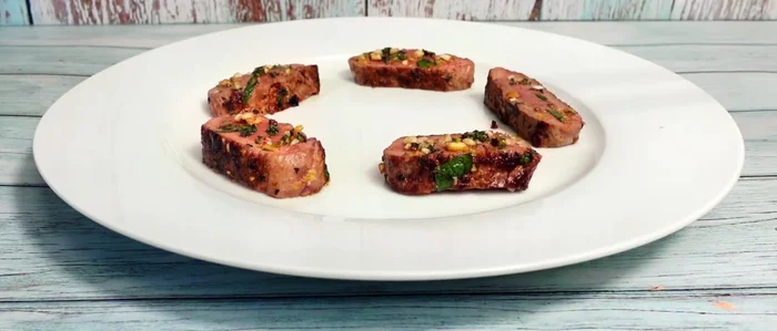 Lammlachs, Bandnudeln, Gemüse und Rotweinsoße auf Tellern anrichten.