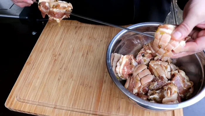 Aufspießen: Die marinierten Schweinebauchwürfel auf die Drehspieße stecken. Dabei darauf achten, dass die Haut nach außen zeigt.