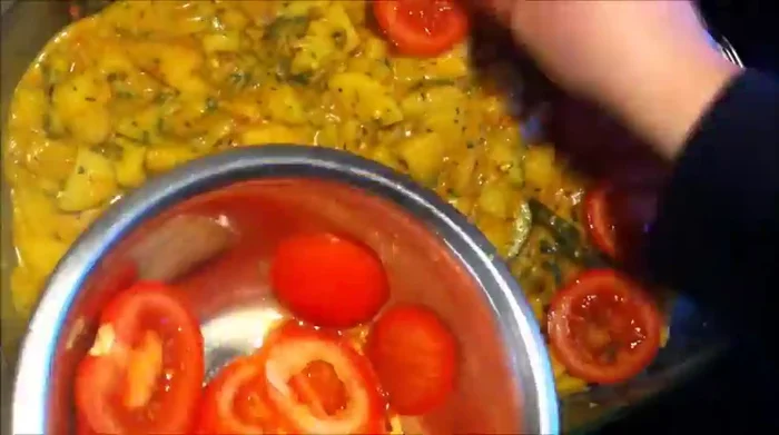 Tomatenscheiben auf die Gemüsemischung legen.