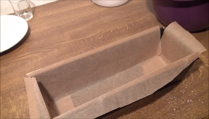Kaiserkuchenform oder Brotform mit Backpapier auslegen.