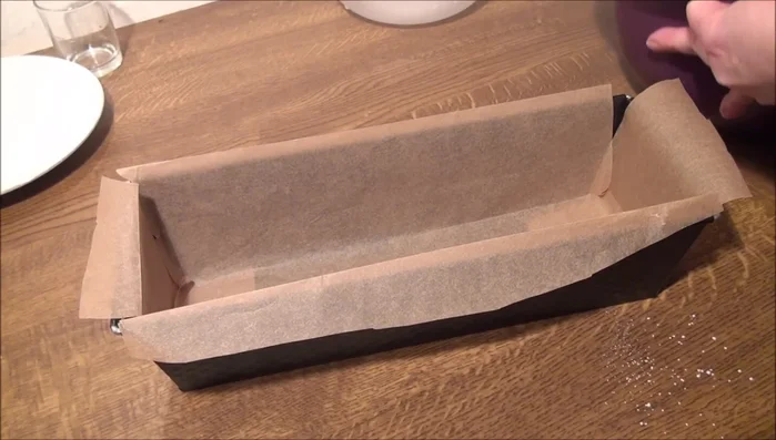 Teig in die Form geben und mit einem nassen Löffel glatt streichen.