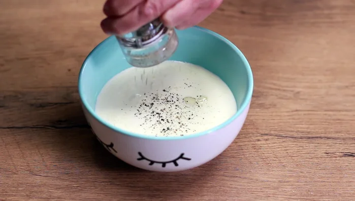 Eier und Sahne verquirlen. Mit Pfeffer, Salz und Curry würzen. Die Sahnemischung über das Fleisch gießen.