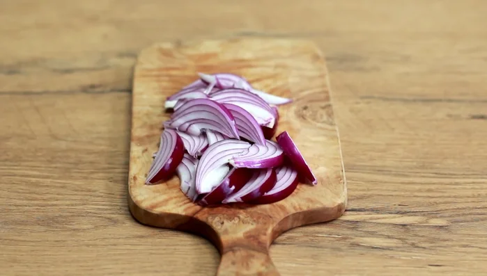 Zwiebel schälen und in Spalten schneiden. Etwas Öl in die Auflaufform geben und ringsherum verstreichen. Zwiebelspalten auf dem Boden verteilen.