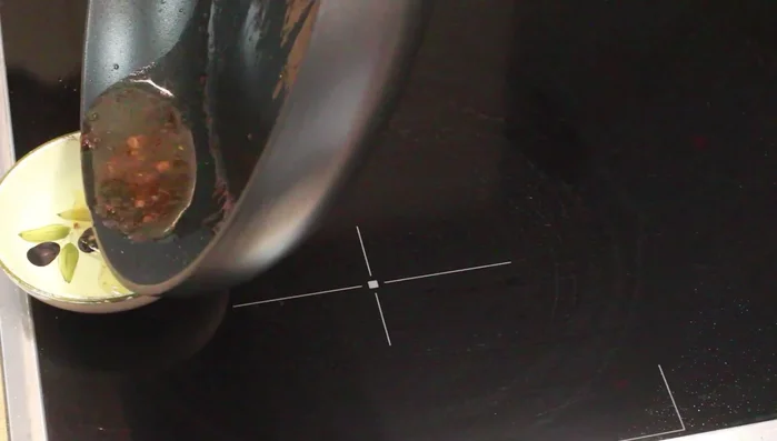 Bratensatz in der Pfanne mit etwas Bratensaft erwärmen. Zwiebeln und Knoblauch darin andünsten.